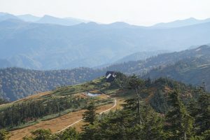 会津駒ヶ岳の山頂近くから駒の小屋を撮影した画像